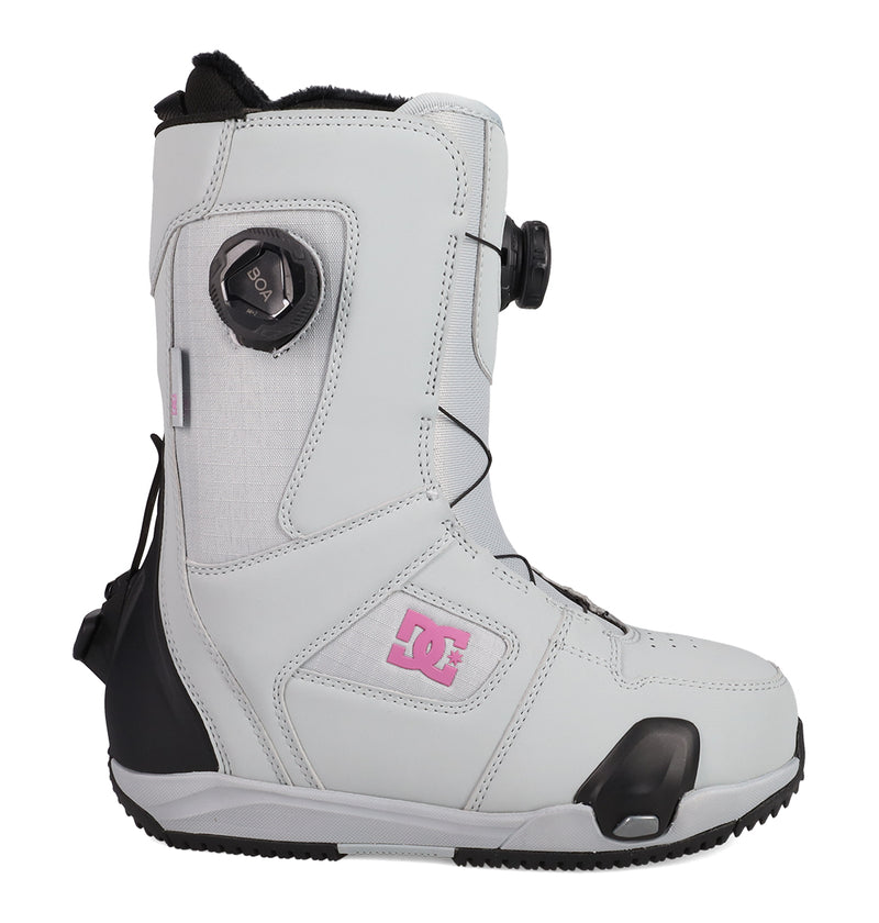A single Women’s Phase BOA® Pro Step On® snowboard boot by DC Shoes is displayed in a side view on a white background. The boot is white with black and pink accents, features the DC Shoes logo on the side, and includes a BOA® Fit System dial.