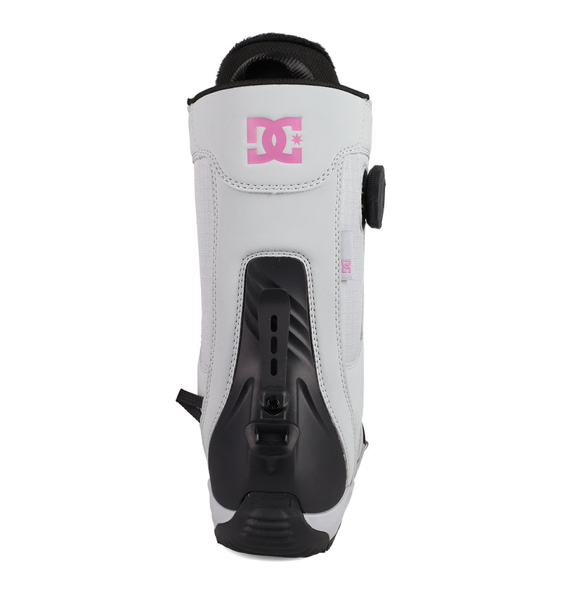 A rear view of the DC Shoes Women's Phase BOA® Pro Step On® Snowboard Boot in white and black, showcasing a pink DC logo on the front, PrimaLoft insulation for extra warmth, and an adjustable BOA Fit System dial on the side.
