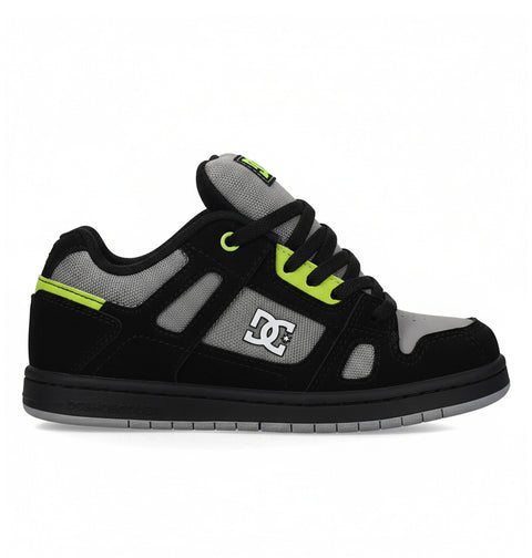 The DC Shoes Kids' Stag is a low-top skate shoe in black, grey, and neon green with a minimal silhouette, thick sole, mesh detailing, black laces, and the DC Shoes logo—perfect for everyday wear.