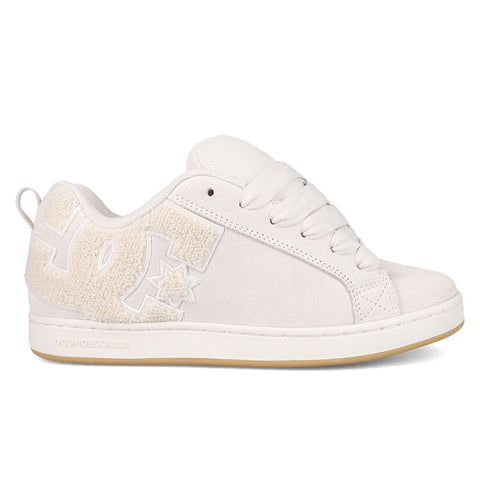 The Women's Court Graffik SD Shoes by DC Shoes are white low-top sneakers with a textured DC logo, white laces, pale beige rubber sole, and a suede upper—offering a simple, clean design for an effortlessly classic look.