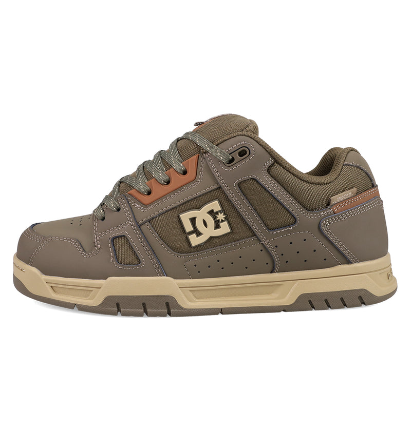 The Men's Stag Shoes by DC Shoes feature taupe and beige tones, mesh and leather panels, a chunky cupsole, and the iconic DC logo—ideal for capturing authentic skate style.