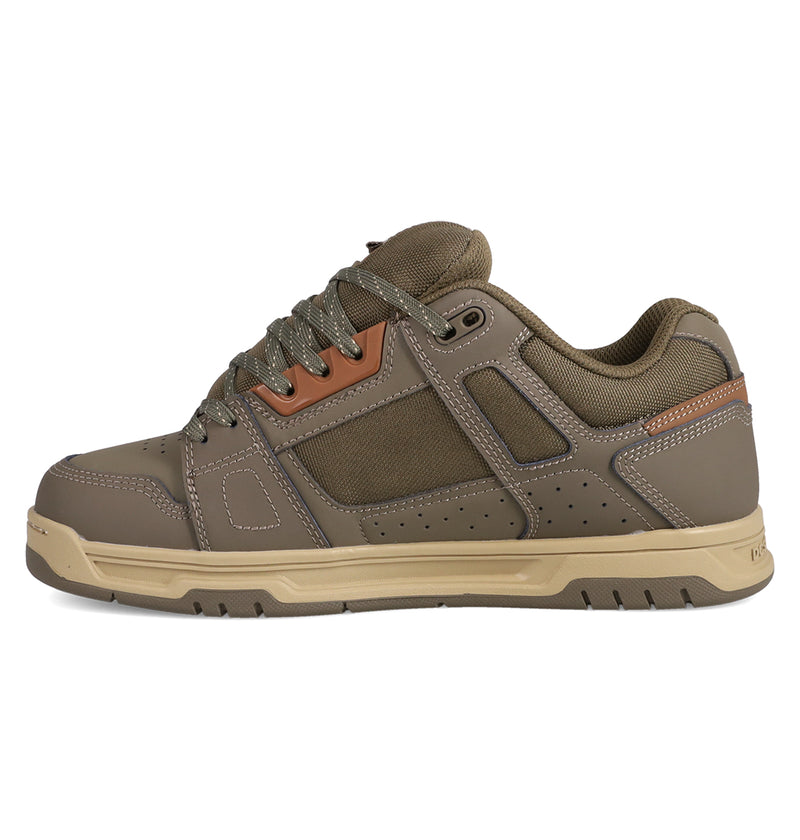 The DC Shoes Men's Stag features brown and tan mesh and leather panels, detailed stitching, perforations, and a thick cupsole rubber sole inspired by skate culture, shown from the side.