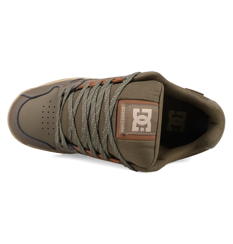 Top view of DC Shoes Men's Stag Shoes in brown and olive green, featuring laces, perforated toe box, cupsole construction, and a tongue logo patch for classic skate style.