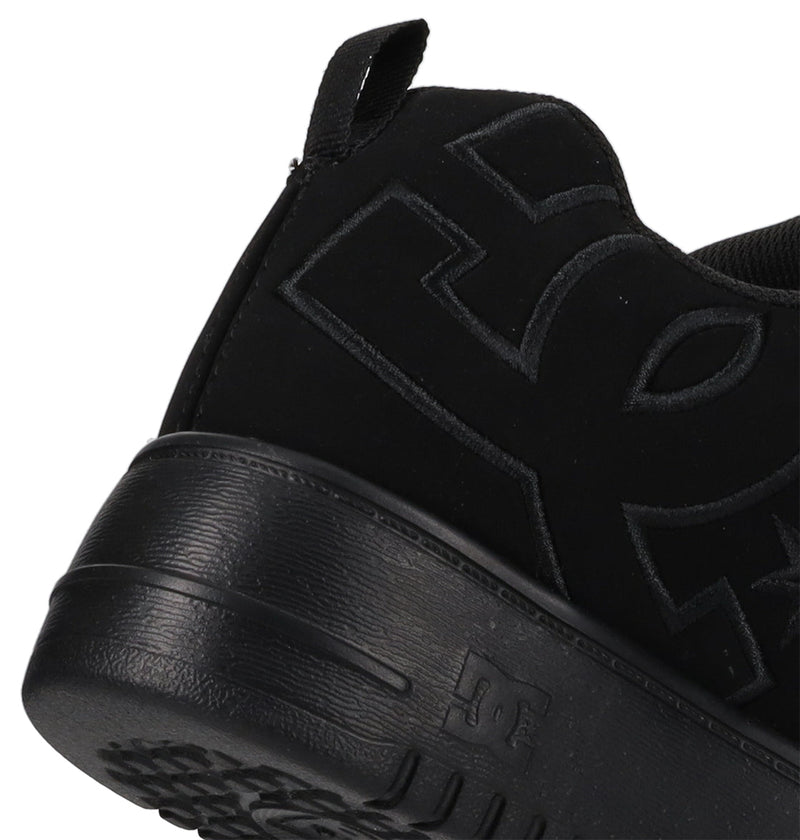 Close-up of the heel and side of DC Shoes Women's Court Graffik Platform Shoes in black, showing the textured sole and embossed DC Shoes logo on the side and heel tab—a bold statement for women's footwear.
