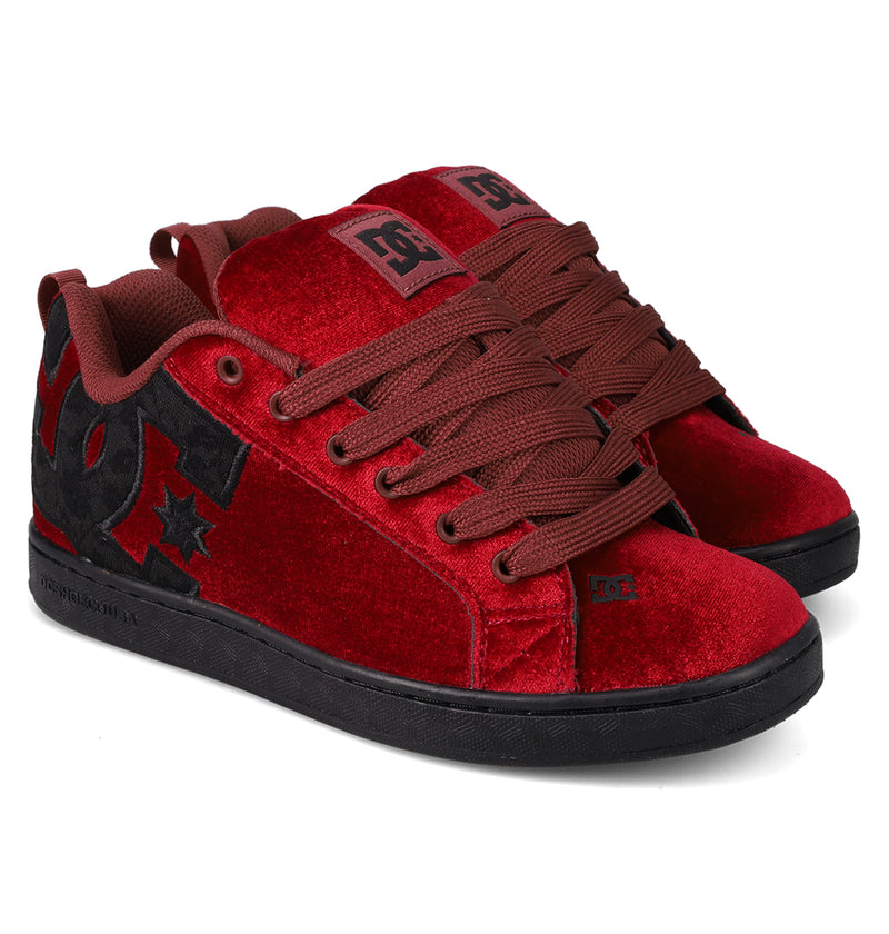 The Women's Court Graffik LE Shoes by DC Shoes feature a red velvet upper, brown laces, black soles, and a large black DC logo with a star on the side. Their puffy silhouette provides style along with comfort and durable premium materials.