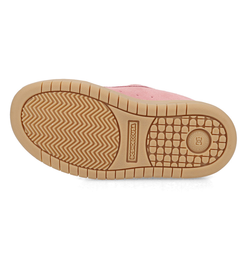The image shows the sole of a Kids' Court Graffik Shoe by DC Shoes, featuring tan rubber tread in zigzag, grid, and circular patterns. Branded text and a logo are visible; the upper part of the shoe is pink.