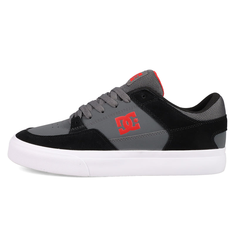 A side-view of the DC Shoes Men's Onyx, featuring a gray and black minimal design with a white sole, red DC logo on the side, black laces, and red accents on the tongue, displayed on a white background.