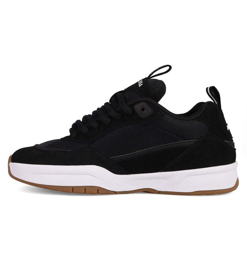 The DC Shoes Men's JS-2 Shanahan Pro Skate Shoes are black sneakers inspired by DC heritage, featuring mesh and suede uppers, black laces, pull tabs, a white midsole, and a light brown gum outsole designed with John Shanahan.