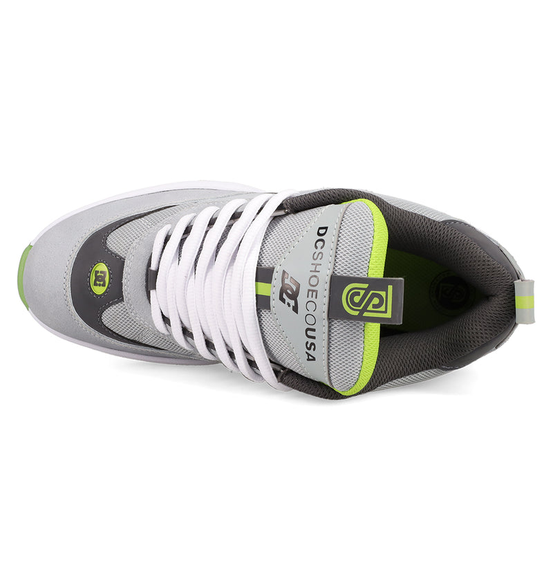 Top view of the Men's JS 2 Shoes by DC Shoes in gray and white with green accents, white laces, and DC SHOE CO USA branding on the tongue, showcasing heritage details inspired by John Shanahan's pro model.