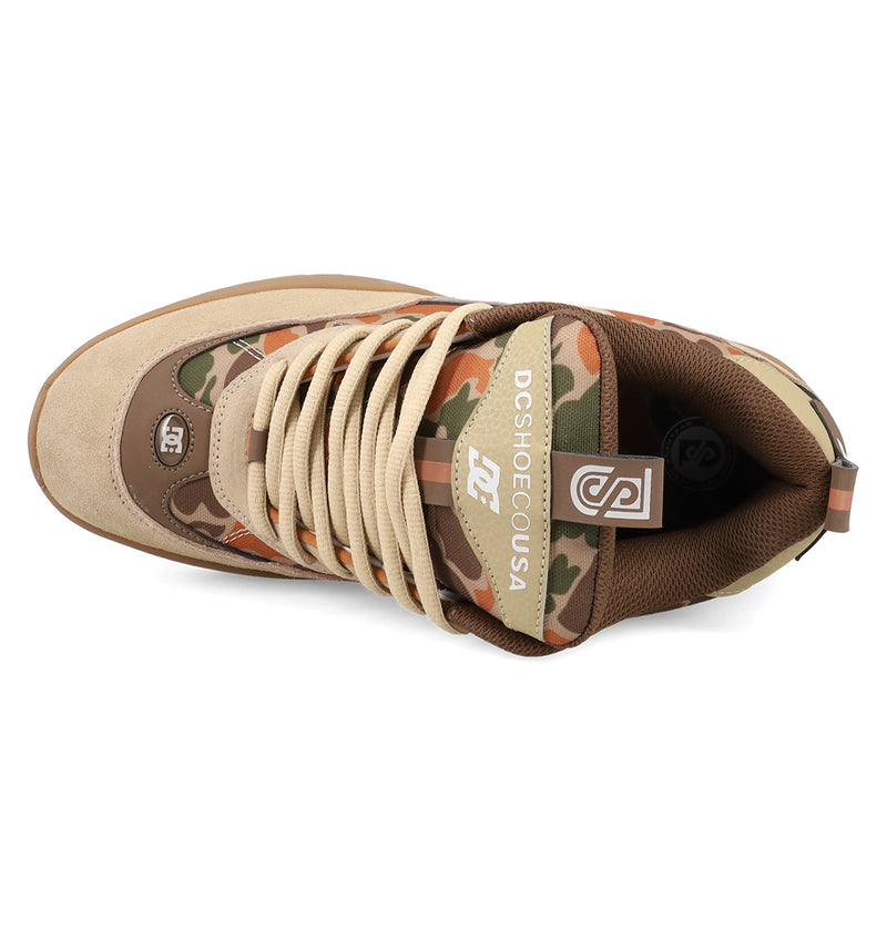 Top view of DC Shoes Men's JS 2 Shoes, a John Shanahan collab with beige laces, brown and tan suede accents, and green-orange camo. Signature DC logos on the tongue and side highlight the brand’s heritage.