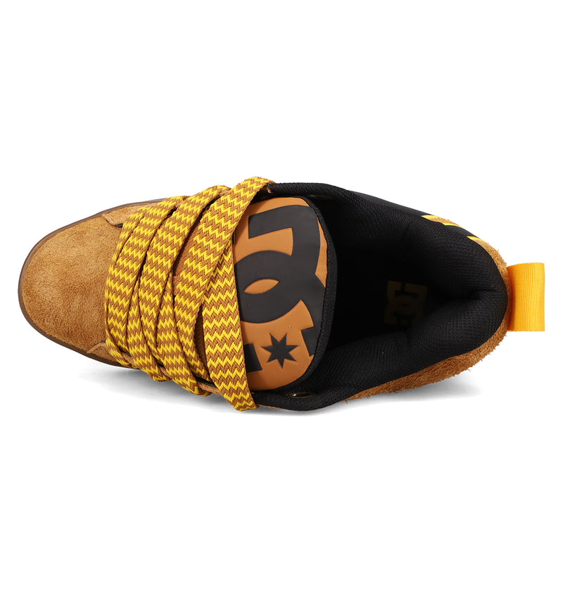 Top view of the DC Shoes Men's Court Graffik Puff Sneakers in brown suede, showing bold upper details, wide yellow/brown zigzag laces, a black tongue with a large orange logo, puffy silhouette, black interior, and an orange heel pull loop.