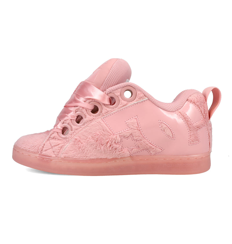 The DC Shoes Women’s Court Graffik Puff Shoes are pink fashion sneakers featuring satin laces, furry textured side panels, a shiny finish, and a translucent pink sole. Displayed from the side against a white background, they showcase the signature puffy silhouette of the Court Graffik Puff collection.