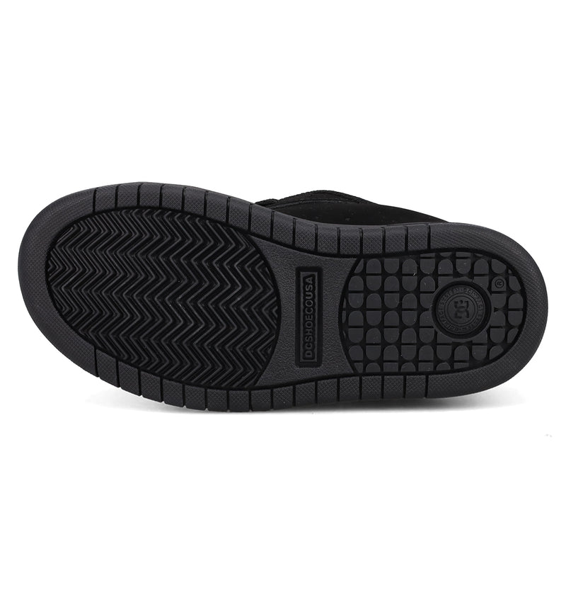 The image shows the black rubber sole of the DC Shoes Kids’ Court Graffik Day Of The Dead sneaker, featuring a circular grip pattern at the heel, a herringbone tread in the center, and a logo mark near the arch.