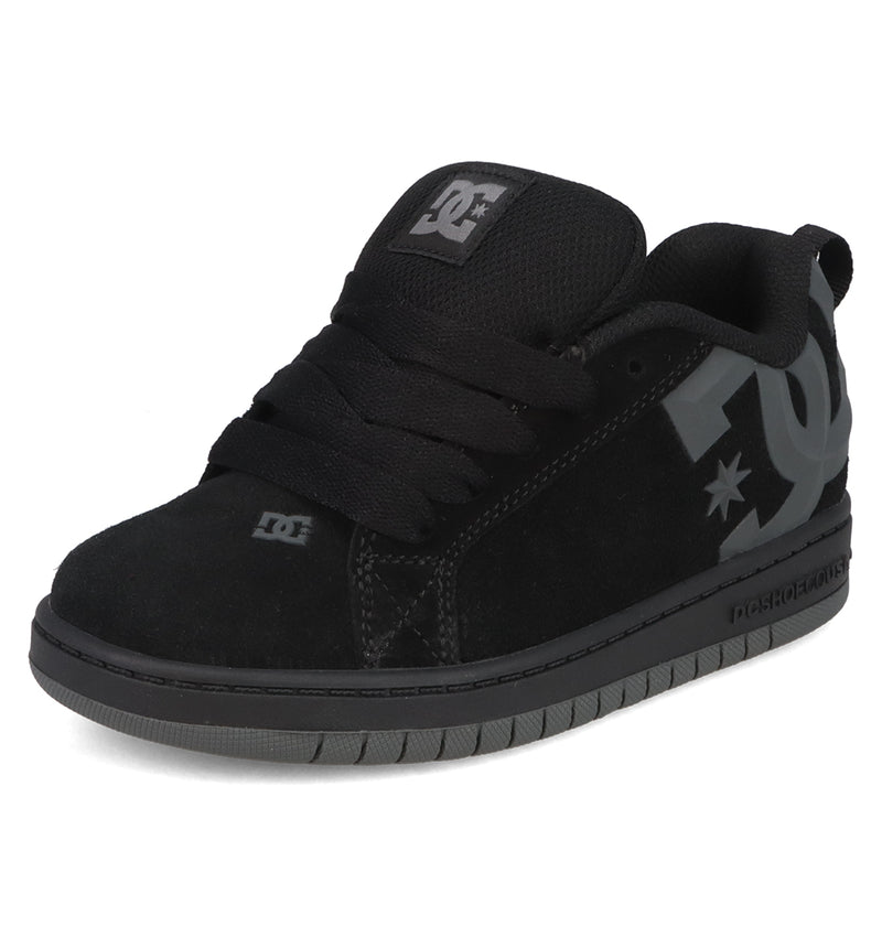The Kids’ Court Graffik Beveled Special Edition Shoes by DC Shoes feature a black suede upper with a puffy silhouette, thick sole, black laces, and a beveled gray DC logo on the side. The shoes are photographed against a white background.