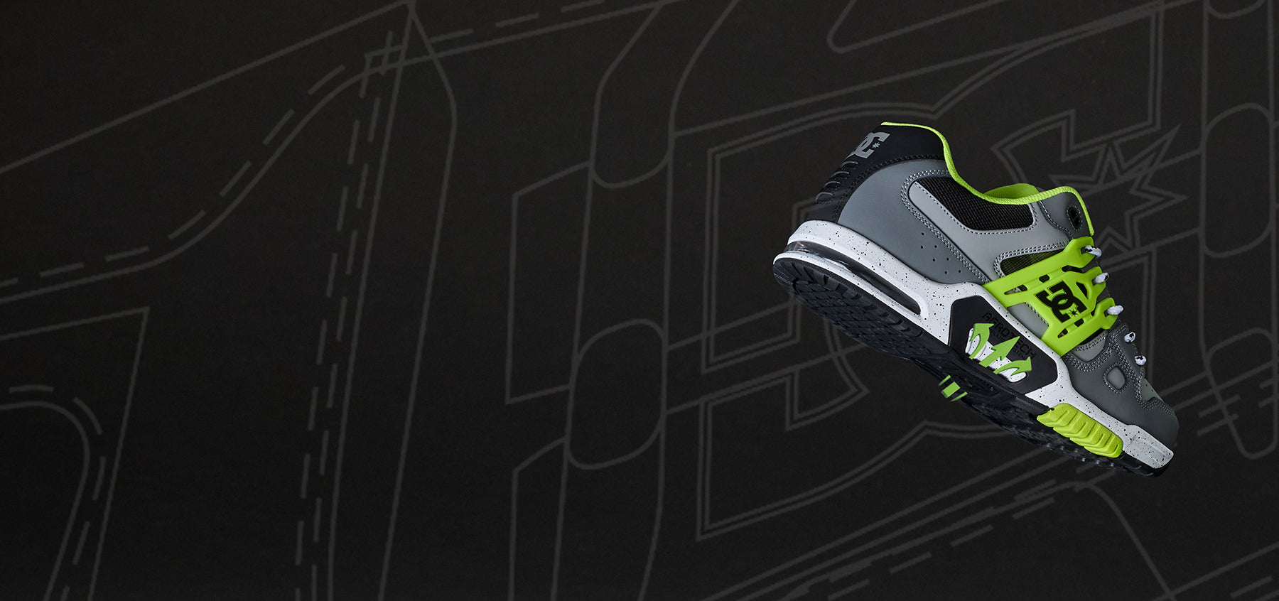 Gray and green sneaker on a black background with abstract designs