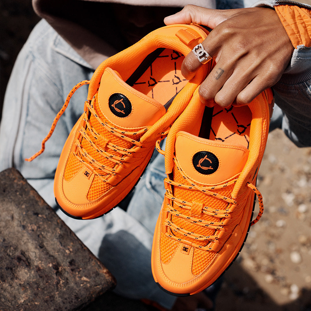 Orange Lucien Clark shoes being held by someone