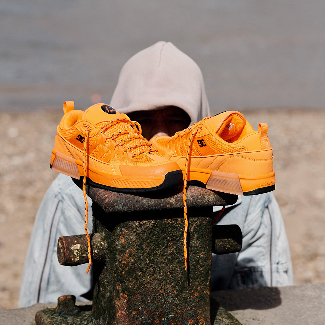 Orange shoes with skate team member Lucien Clark in the background.