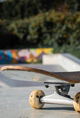 Skateboard on a concrete surface with a blurred colorful background