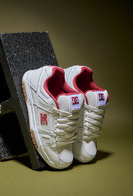 White sneakers with red accents on a dark surface