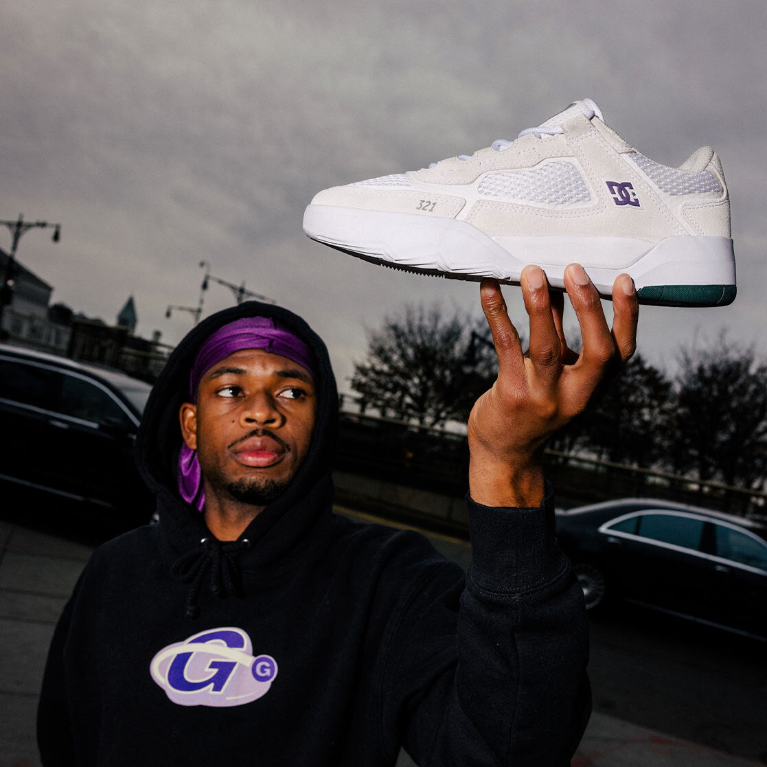 Ish Cepeda holding the Men's Metric S X Ish Cepeda Shoes in White/Purple