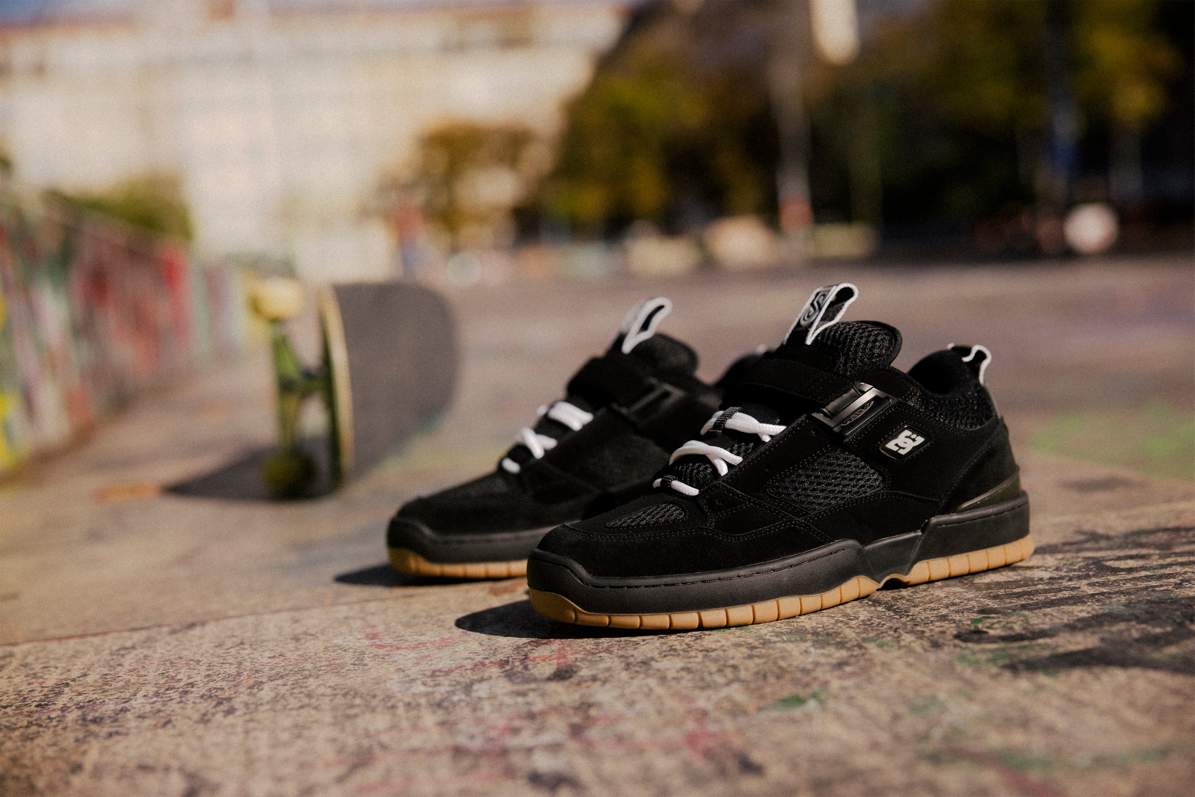 Black sneakers with white laces on a textured surface with a blurred background