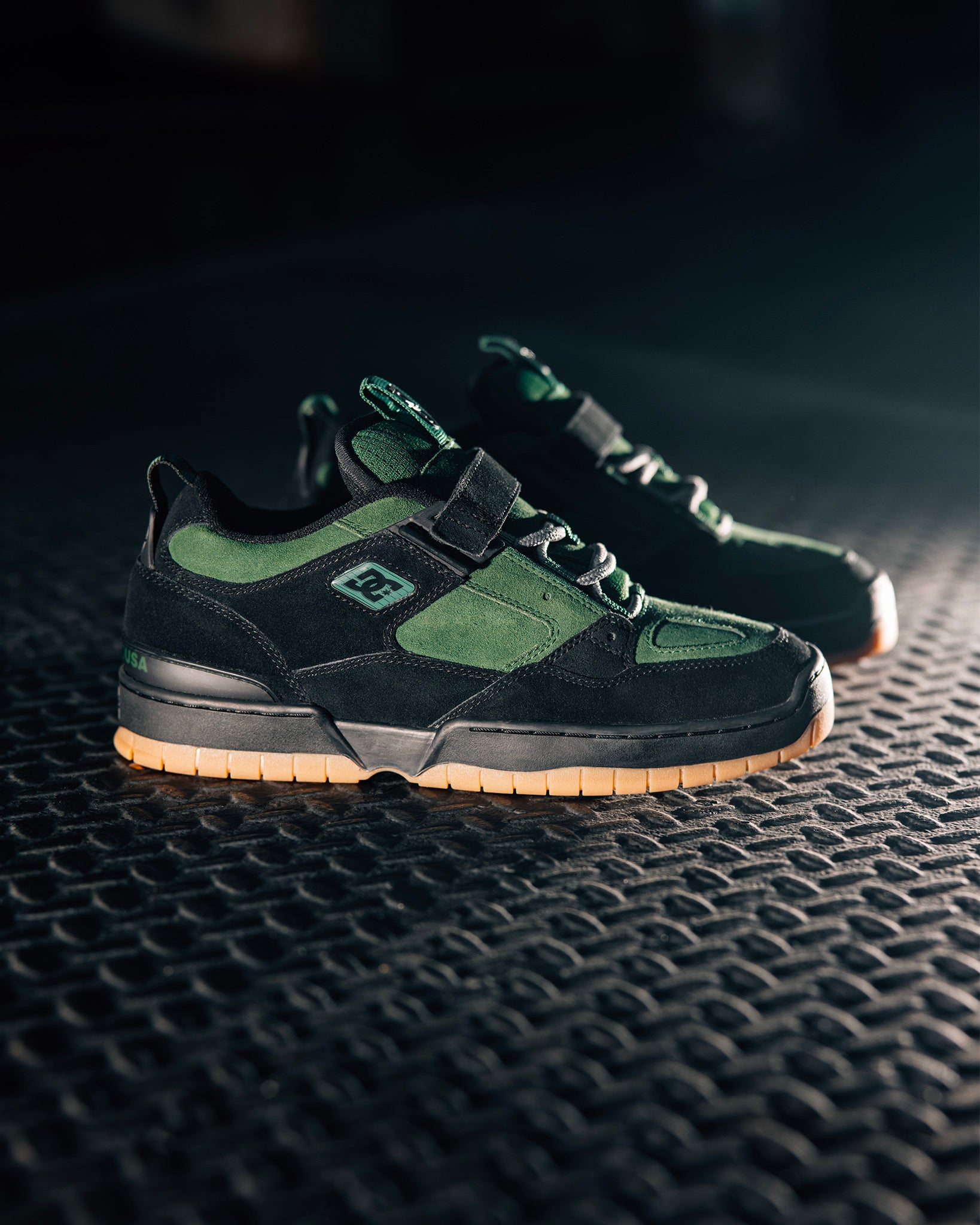 The JS1 shoes in green and black on some type of platform