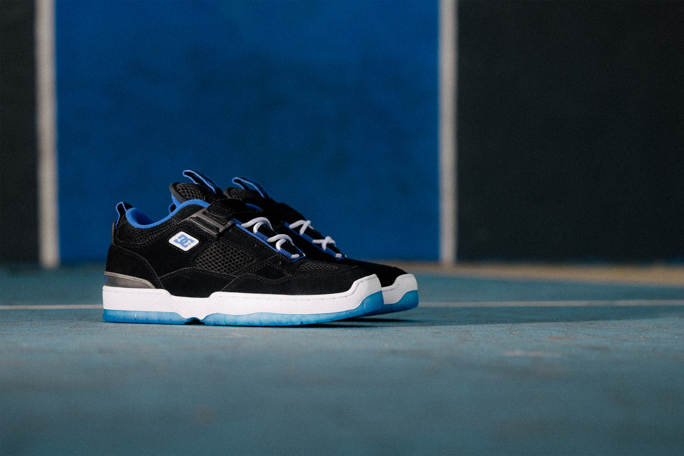 Black sneakers with blue accents on a blue surface