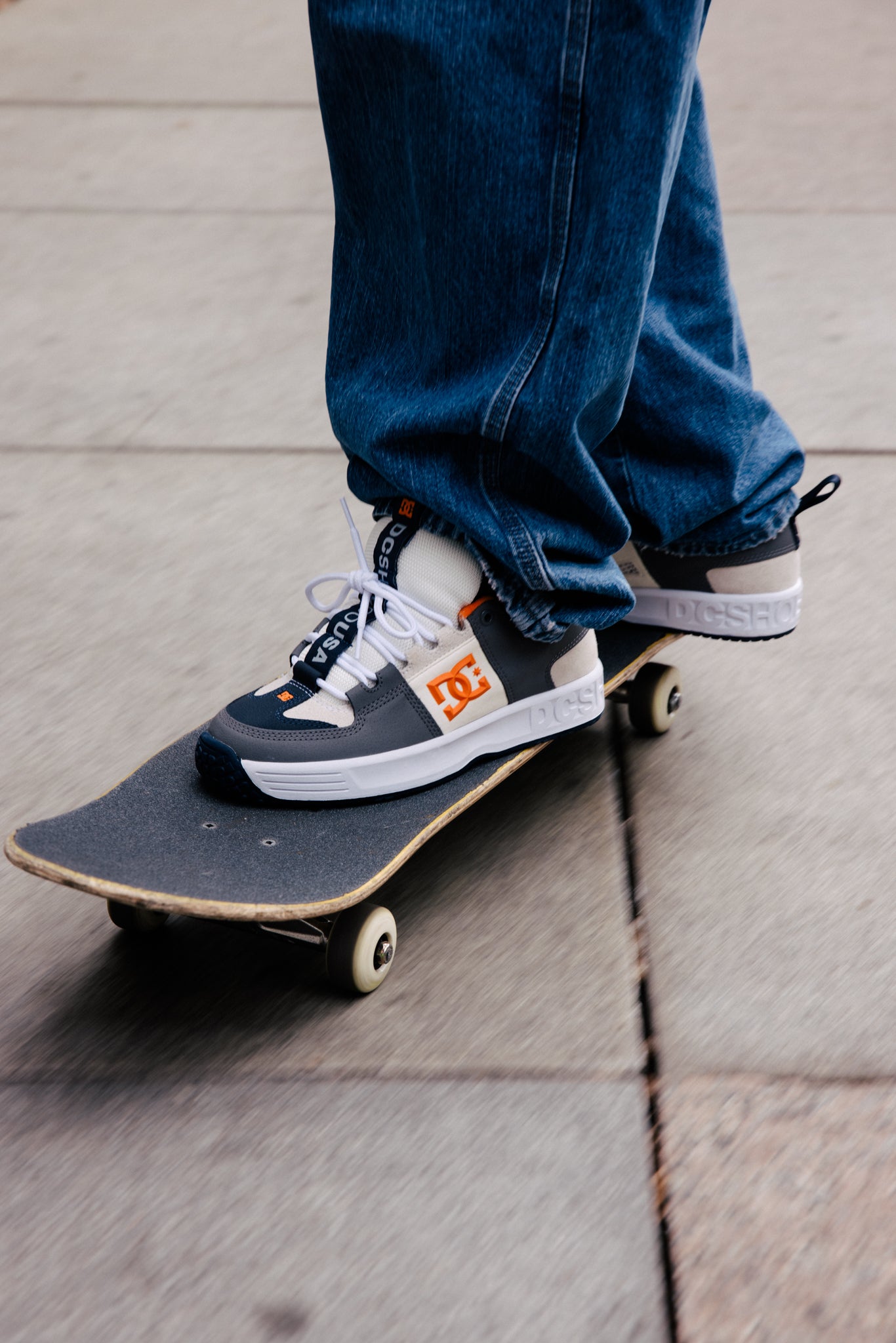A person riding a skateboard wearing the Lynx OG Shoes