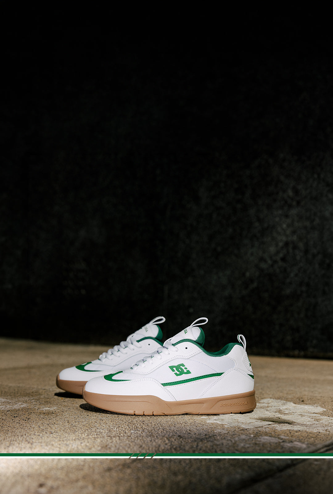 White sneakers with green accents on a dark background