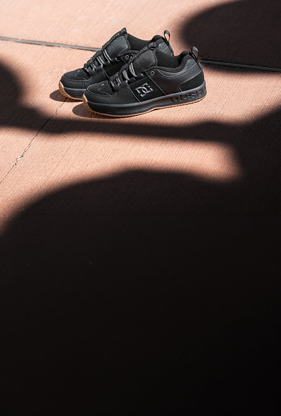 Black sneakers on a textured surface with a dark background
