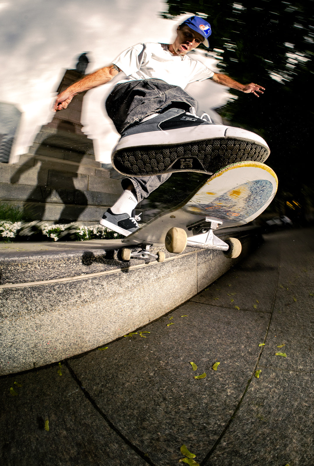 Skateboarder performing a trick in black and white sneakers