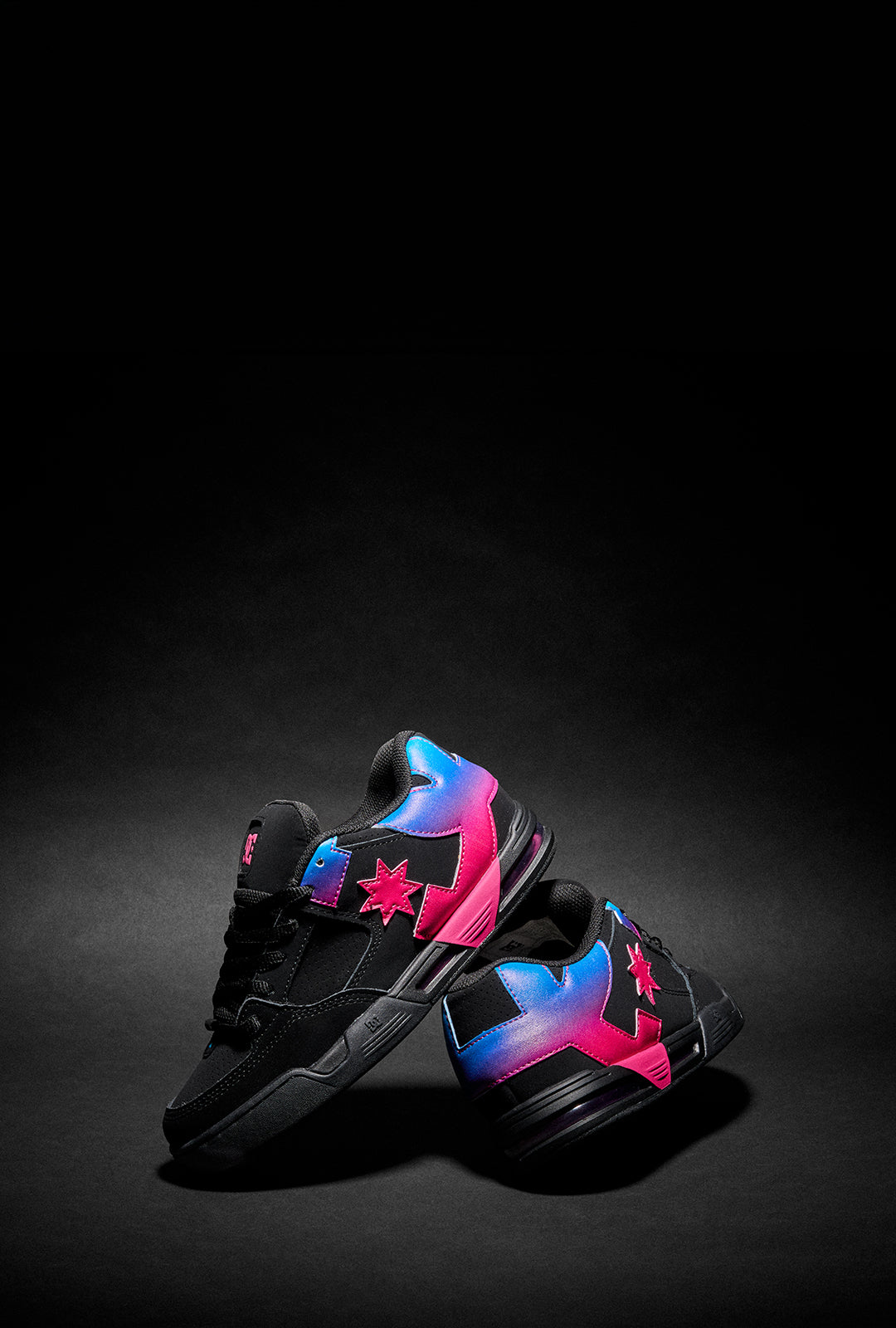 Black sneakers with colorful pink & blue gradient logo on a dark background