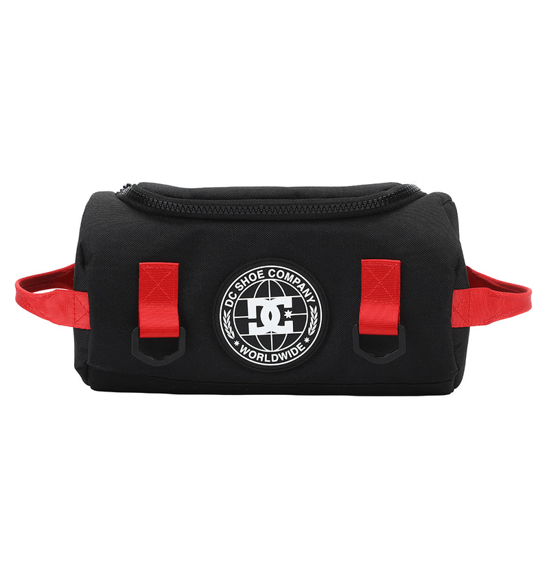 The DC Shoes DC Runner Dopp Kit is a black zippered pouch with red side handles and loops, featuring a round white DC Shoe Company Worldwide logo on the front.