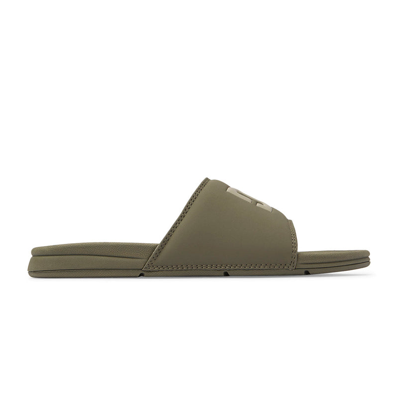 The image shows a single Men's Bolsa Slide sandal by DC Shoes in olive green, displayed in side profile on a white background. It features a wide top strap and flat sole, perfect for post-skate comfort.