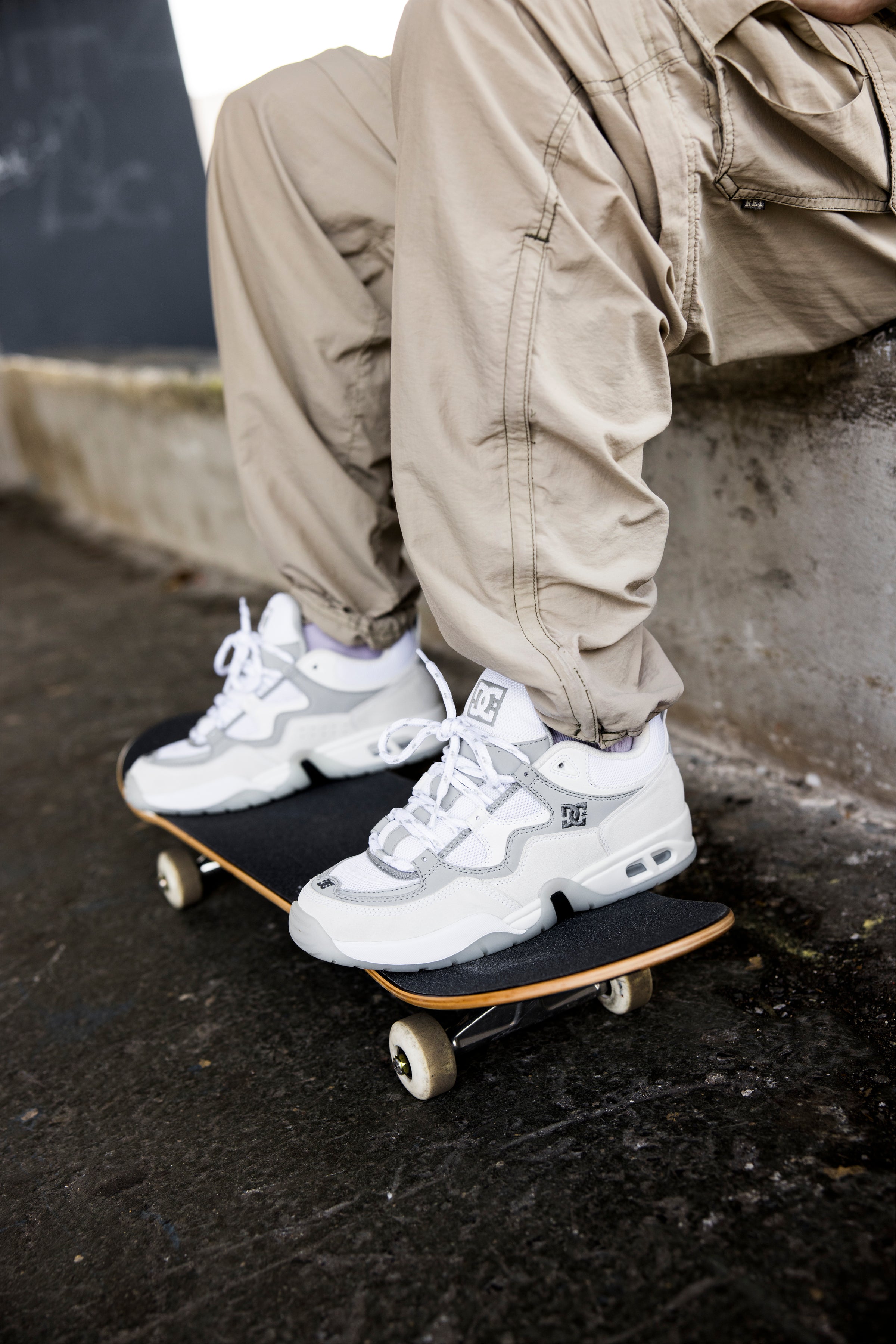 Heritage shoes in white and grey worn by someone with their feet on a skateboard