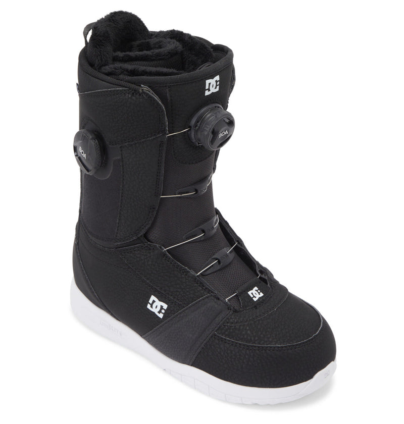 The DC Shoes Women's Lotus BOA® Snowboard Boots in black feature a white UNILITE outsole, Dual Zone BOA® Fit System for adjustable lacing, and a faux fur lining, shown at an angle on a white background.