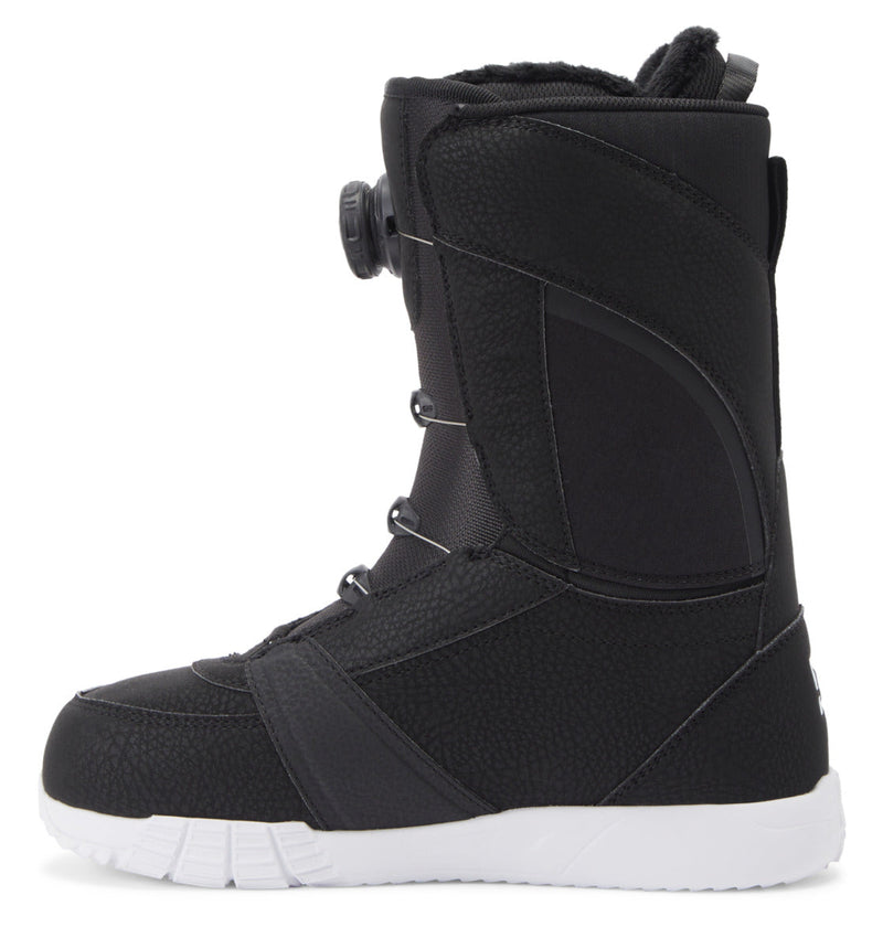The DC Shoes Women's Lotus BOA® Snowboard Boots, shown from the side, are black with a white UNILITE outsole. They feature textured material, reinforced stitching, and a Dual Zone BOA® Fit System by the ankle for secure fastening.