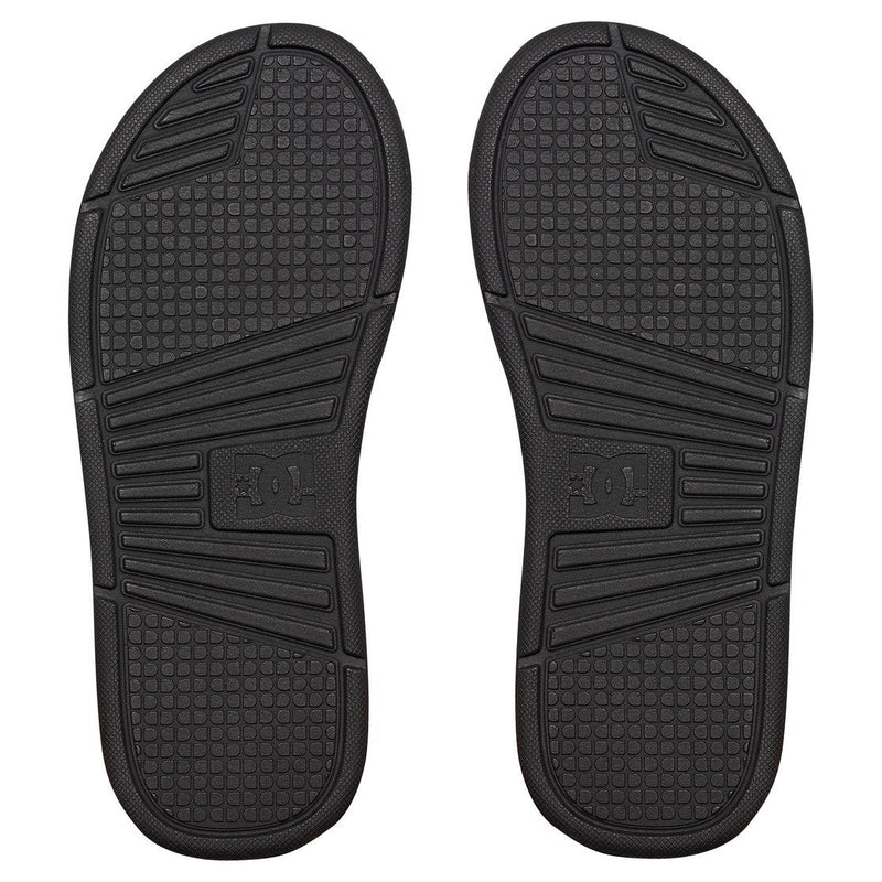 The DC Shoes Men's Bolsa Slides feature black soles with textured tread and rectangular sections, shown side by side on a white background—these comfortable slides are the perfect choice after a skate session.