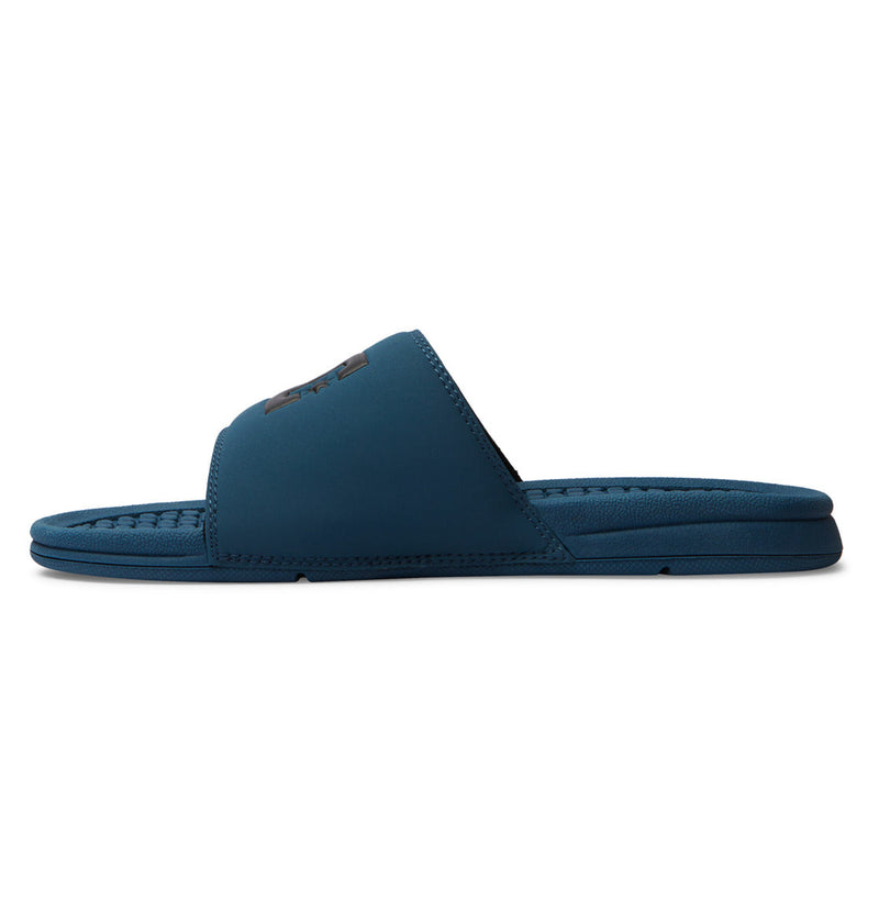 The DC Shoes Men's Bolsa Slides feature a blue design with a textured footbed and a wide single strap—ideal for easy comfort after your skate session.