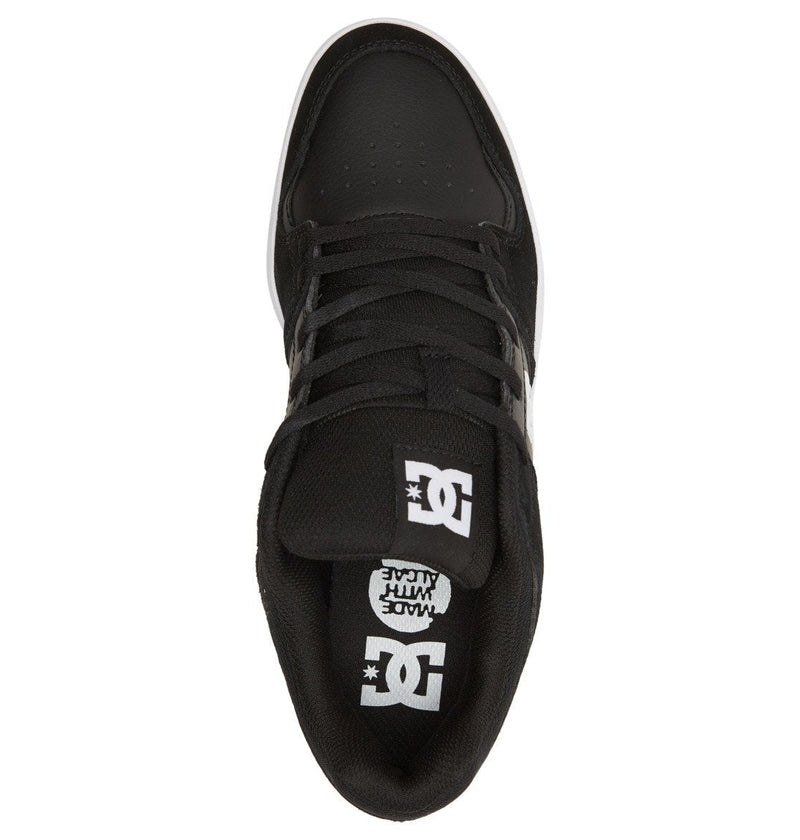 Top view of Men's DC Cure Shoes by DC Shoes in black, featuring black laces, a white DC logo on the tongue, “MADE WITH FUN” text on the insole, and a street-ready design with a white sole along the edge.