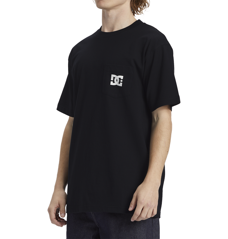 A person wearing the Men's DC Star Pocket Tee by DC Shoes, featuring a relaxed fit and small white logo on the chest pocket, stands against a plain white background paired with dark jeans.