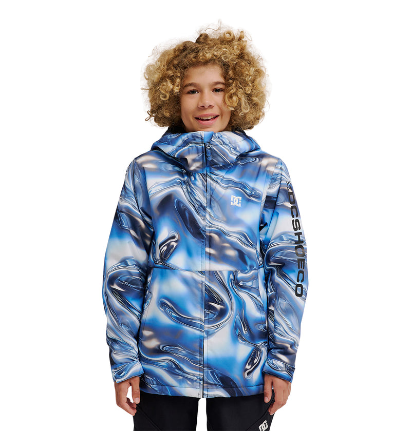 A smiling child with curly hair wears the DC Shoes Basis Youth Jacket, featuring a blue and white marble pattern and “DC SHOES CO” printed on the left sleeve, standing against a white background.