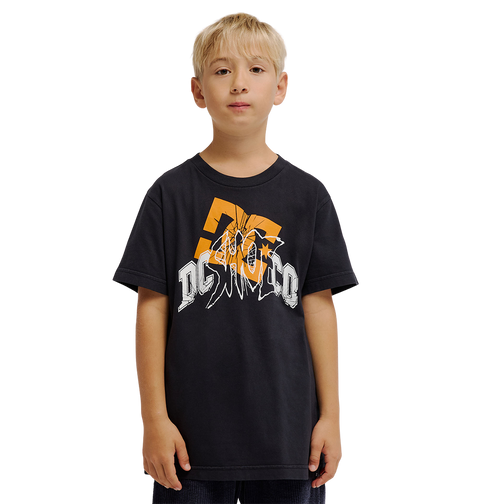 A young boy with blonde hair wears the DC Shoes Speratic Tee Youth, a black graphic skate t-shirt with bold orange and white designs, standing against a plain white background.