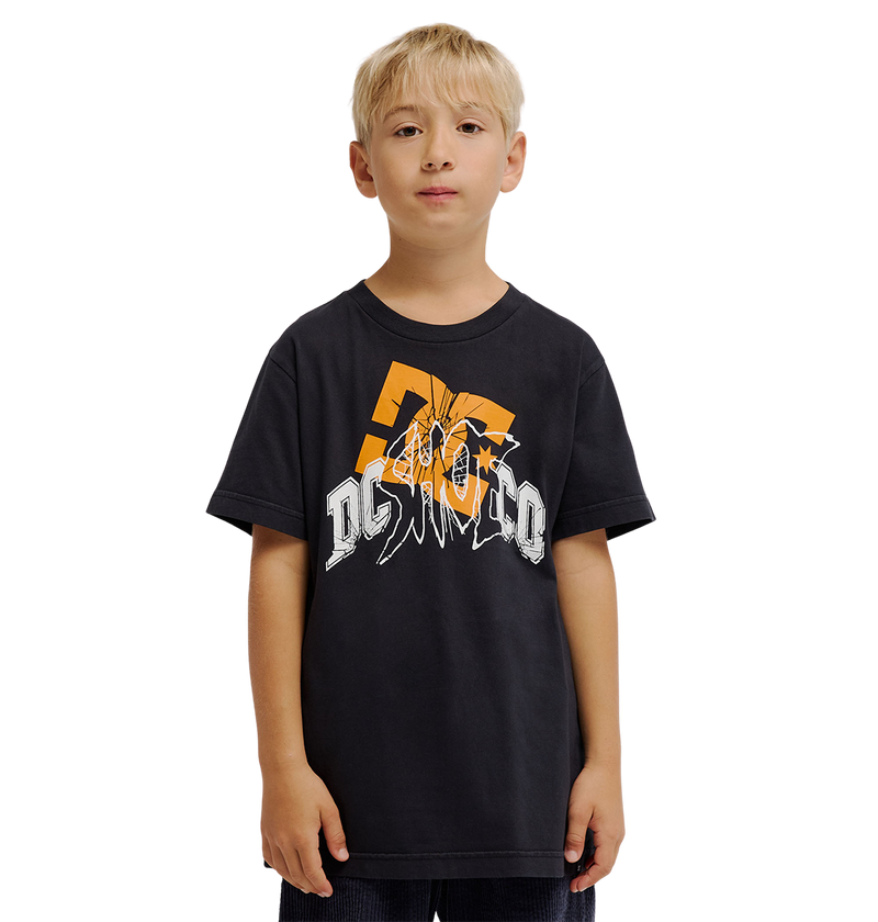 A young boy with blonde hair wears the DC Shoes Speratic Tee Youth, a black graphic skate t-shirt with bold orange and white designs, standing against a plain white background.