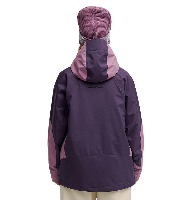 A person wearing the DC Shoes Everfrost Jacket, a two-tone purple waterproof jacket engineered for peak snow performance, along with a purple knit hat, stands facing away from the camera against a plain white background.