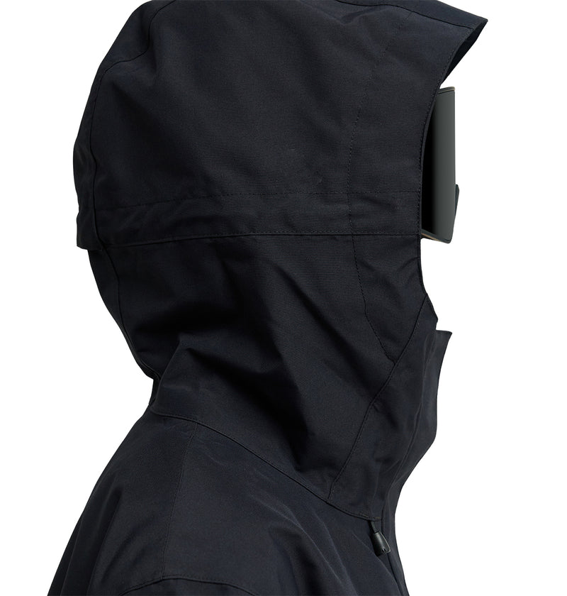 A person is shown from the side wearing the DC Shoes Cruiser Jacket in black, featuring an insulated design with a hood. They have a large rectangular visor covering their face, set against a plain white background.