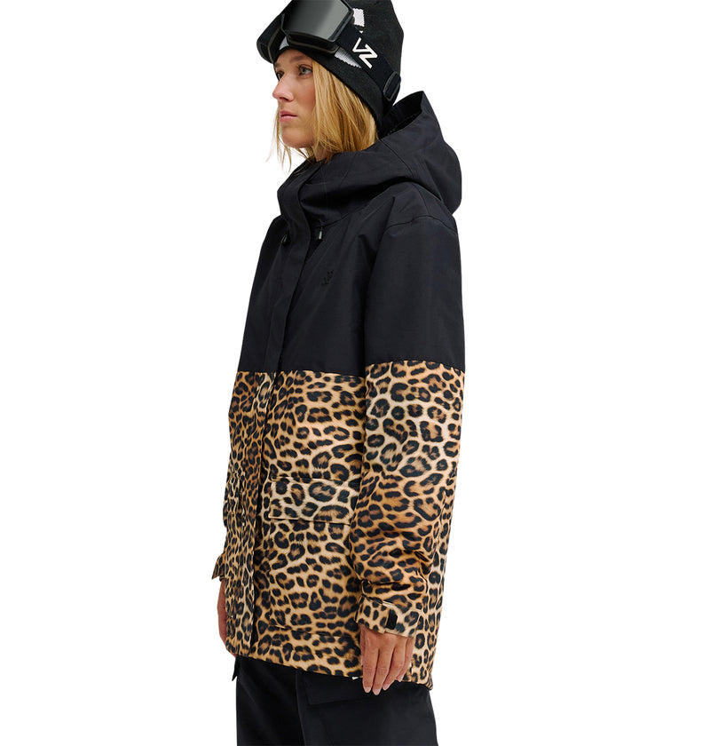 Wearing the DC Shoes Cruiser Jacket—featuring black and leopard print—a person stands facing left against a white background, paired with black pants, a black hat, and ski goggles.