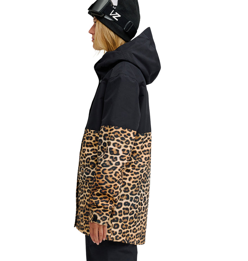 A person in side profile wears the DC Shoes Cruiser Jacket—a black insulated jacket featuring a leopard print lower half—paired with a black beanie and ski goggles on top. The hood is up, set against a white background.