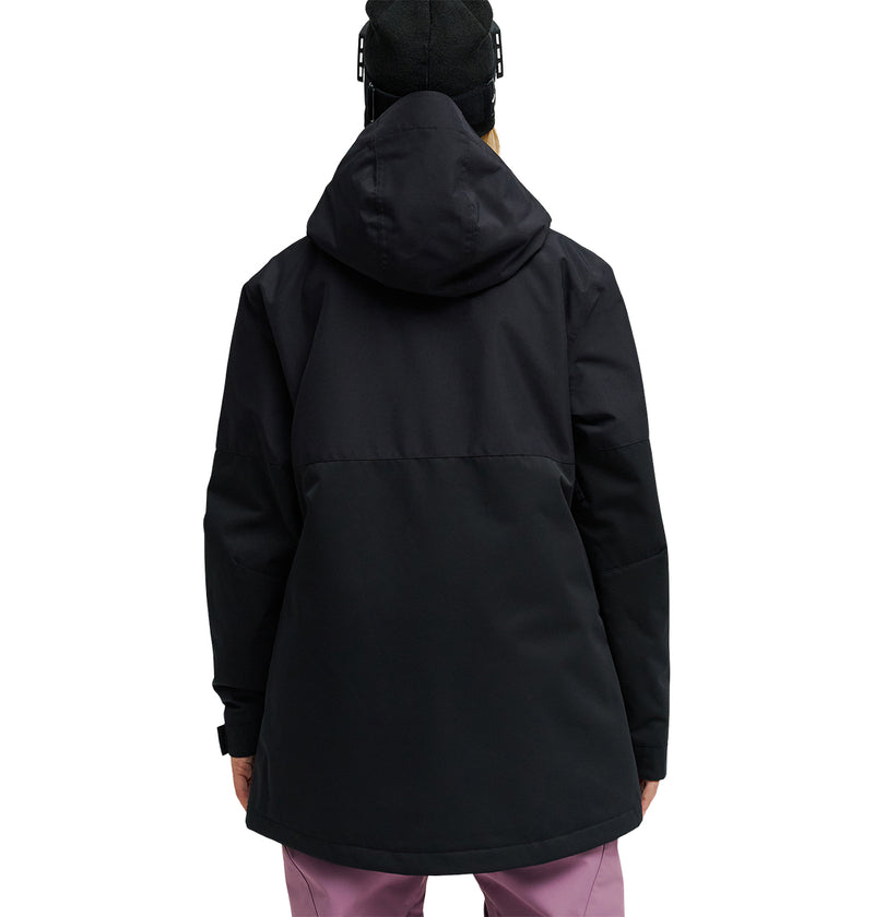 A person is pictured from the back against a white background, wearing a black DC Shoes Cruiser Jacket and pink pants.