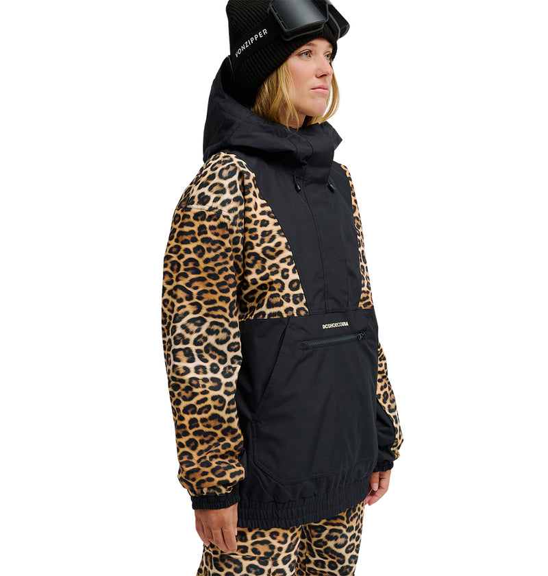 A person wearing the DC Shoes Chalet Anorak—a black and leopard-print insulated winter jacket—paired with matching leopard-print pants, a black beanie, and ski goggles on their head stands against a white background, perfectly outfitted for snow performance and enhanced waterproofing in cold conditions.